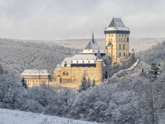 Zimní pohled na Karlštejn od jihovýchodu ze sedla mezi Plešivcem a Haknovou. Zdroj: Wikipedie, CC BY-SA 4.0. Autor: Radomír Šalda