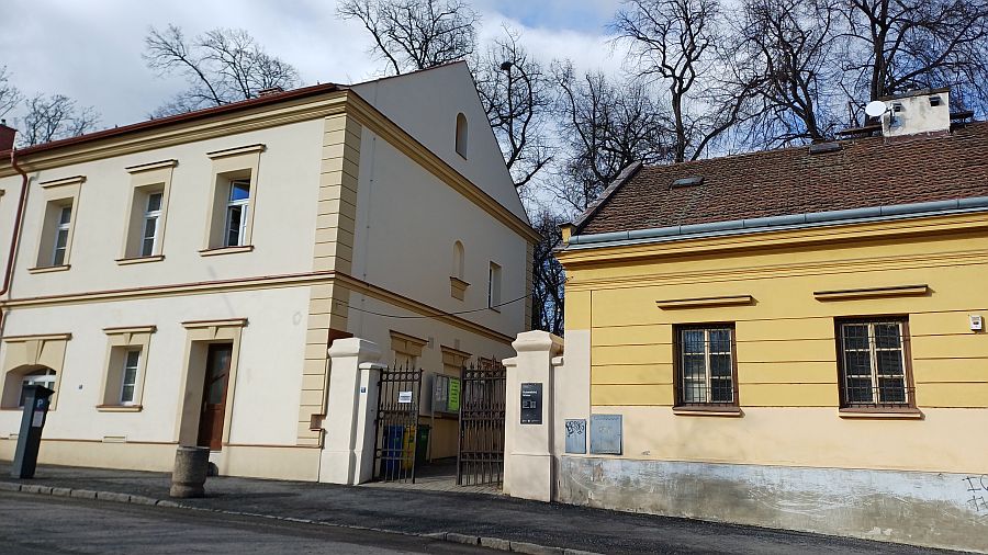 Vstupní brána na hřbitov, vlevo azylový dům.